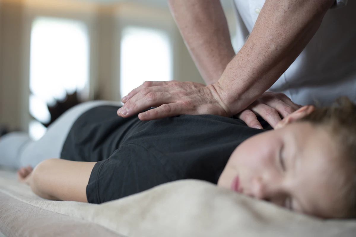 Chiropractor's hands working on a patient's lower back