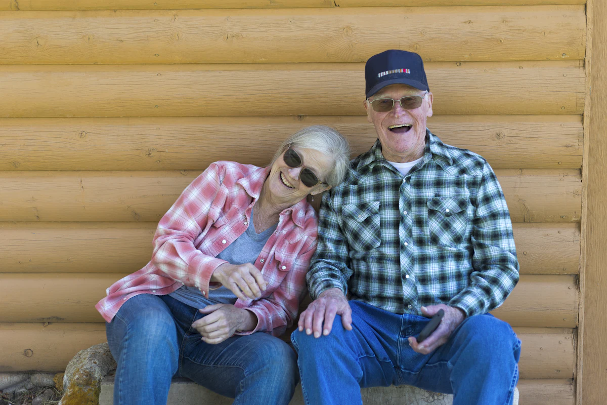 Older couple laughing together on a sunny porch