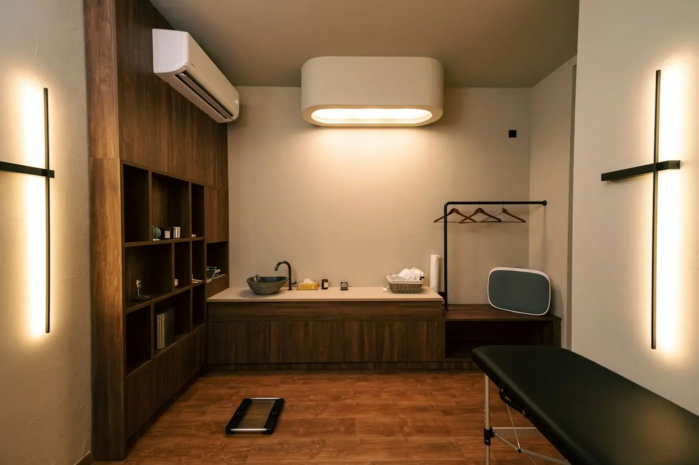 A treatment room with warm wood shelving and soft vertical lights