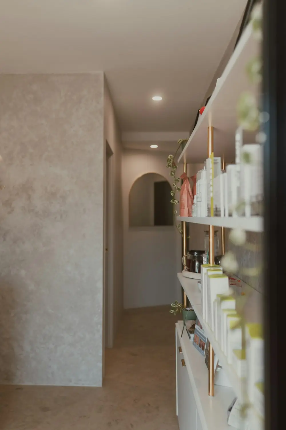 Shelves of skincare products along a textured plaster wall