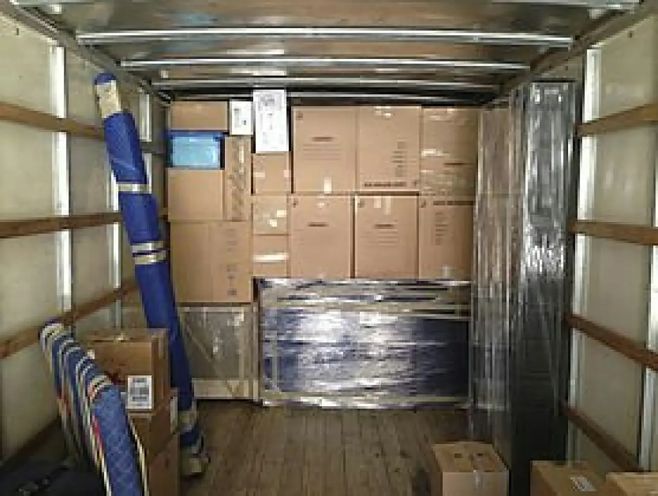 The inside of a moving truck, tightly loaded with boxes and wrapped furniture