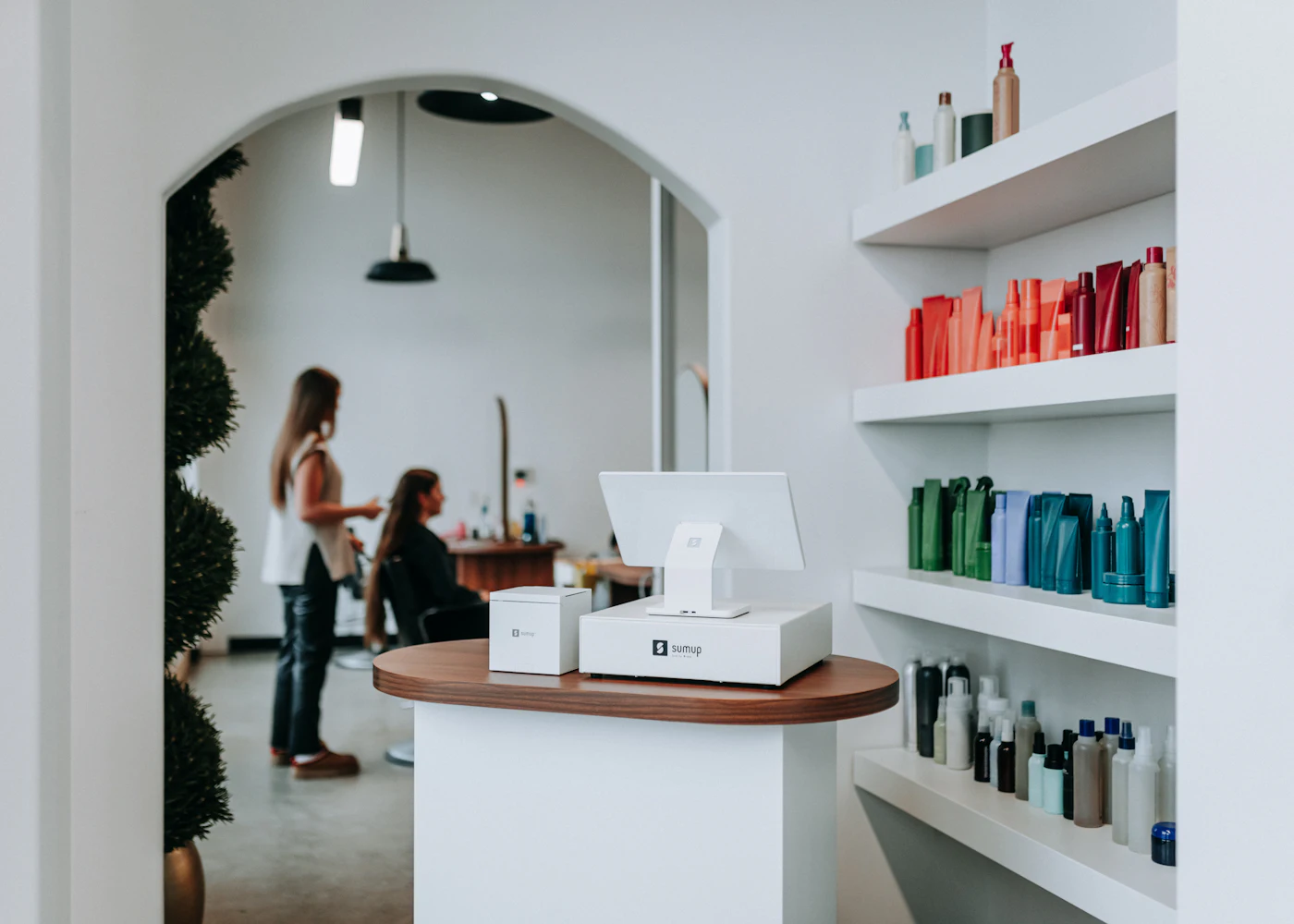 Bright white salon reception with arched doorway