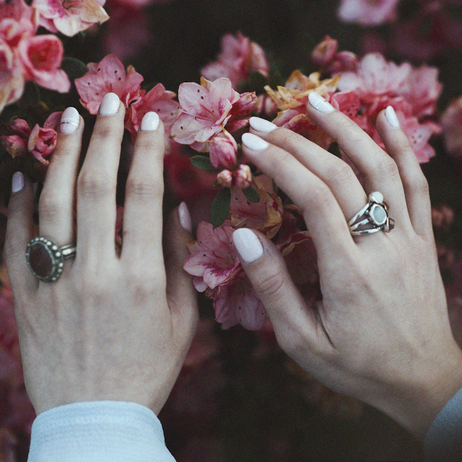 Soft pink nails against blooming flowers