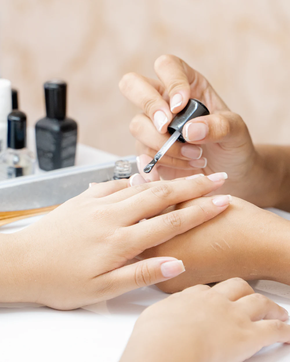 Nail artist applying polish during a manicure
