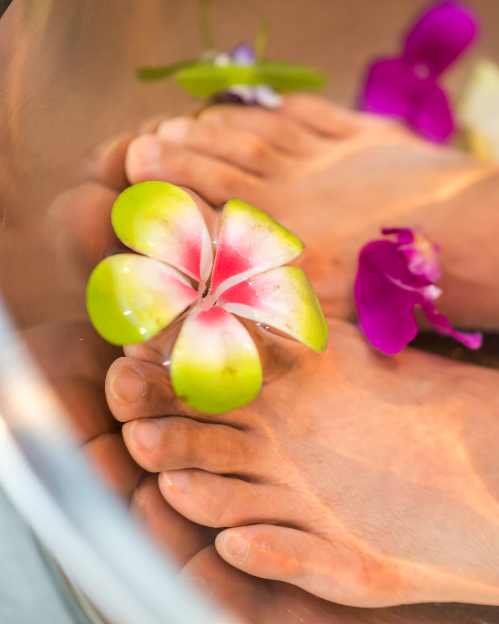 Spa pedicure with orchid petals in a warm foot bath