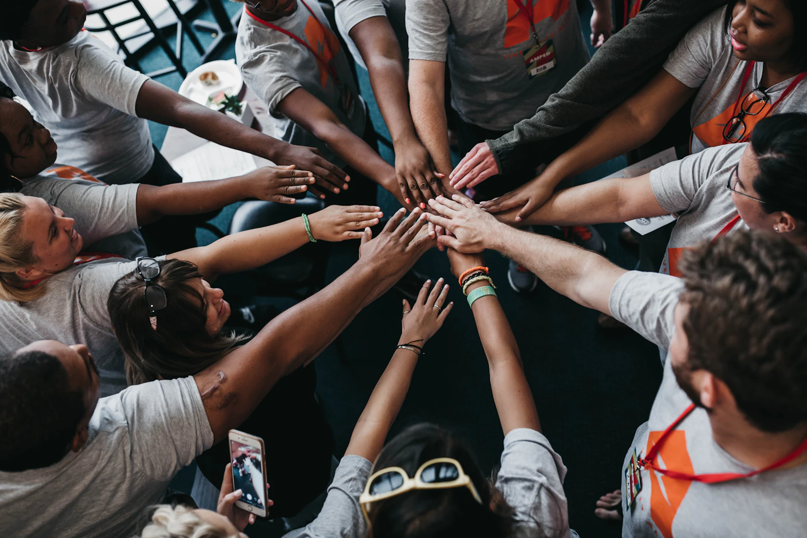 Volunteers stacking their hands together before a pantry shift