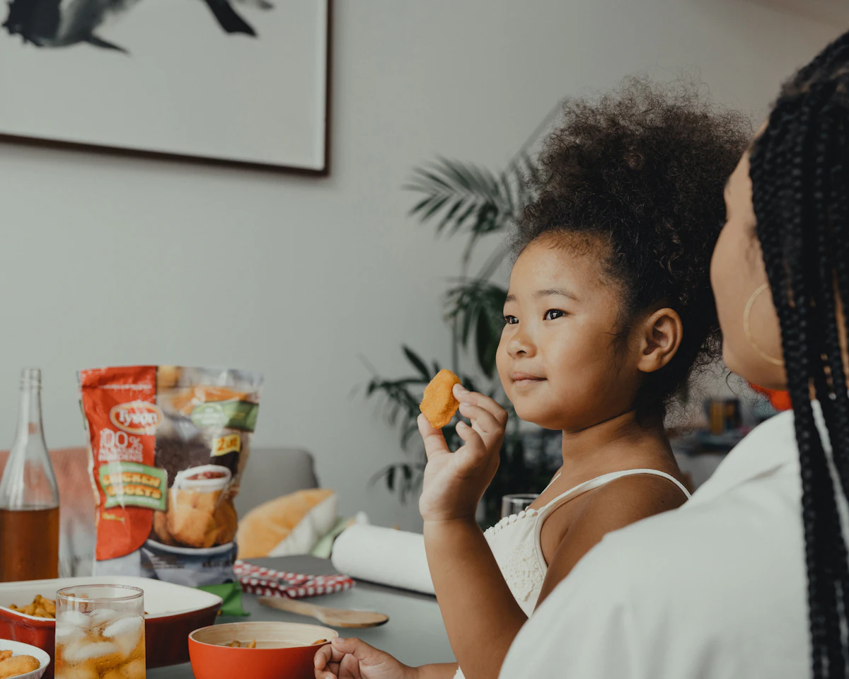 Young girl smiling while eating a healthy snack