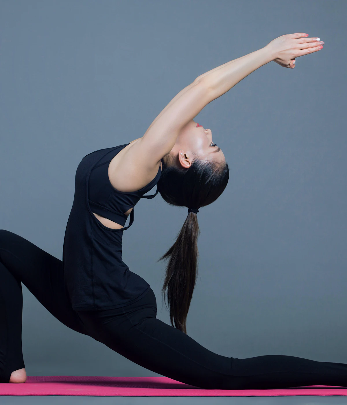 Woman in a deep lunge stretch on a mat