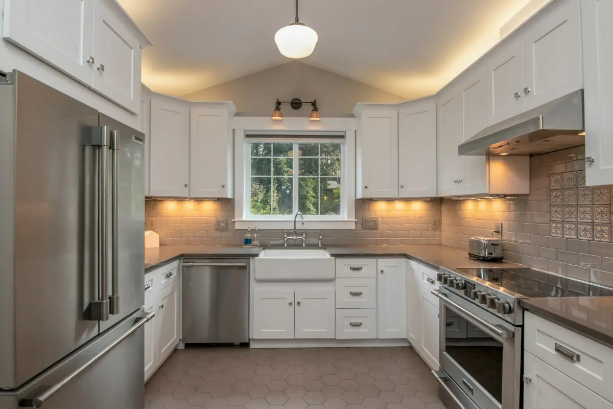 A white kitchen with a farmhouse sink under a window