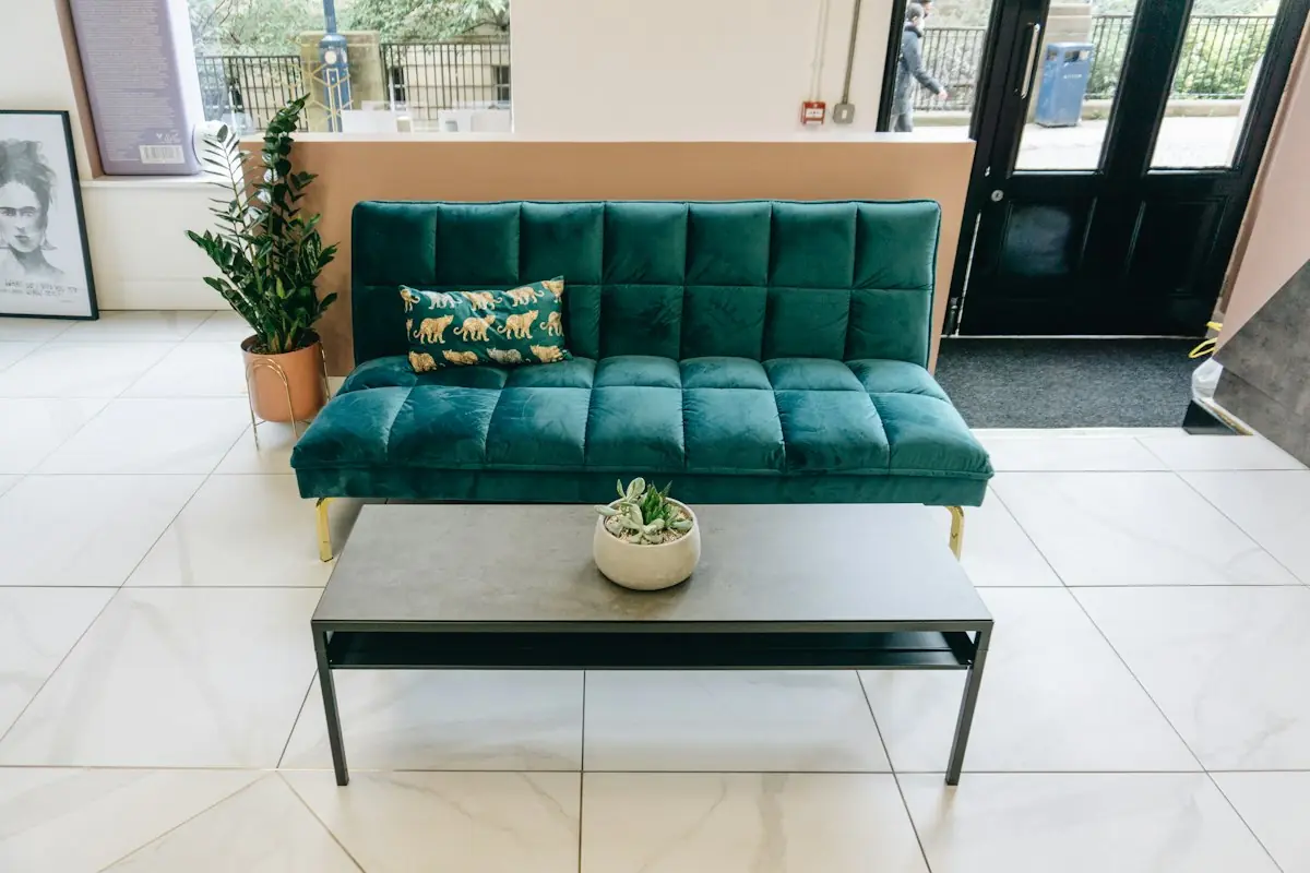 The waiting area with a green velvet sofa